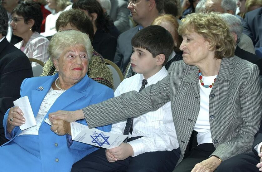 At a 2005 Holocaust Remembrance Day ceremony at the Harold Washington Library, Holocaust survivors Barbara Steiner (left) and Fritzie Fritzshall shared a moment. Mrs. Steiner was the keynote speaker. Her grandson Robby Blumstein sat between them. | Sun-Ti
