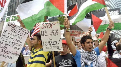 Shahid Mohammed (left) and Firas Harb waving Palestinian flags, both of Chicago, demonstrate at the Coalition for Justice in Palestine counter protest Tuesday afternoon outside the pro-Israel rally. | Michael Schmidt/Sun-Times