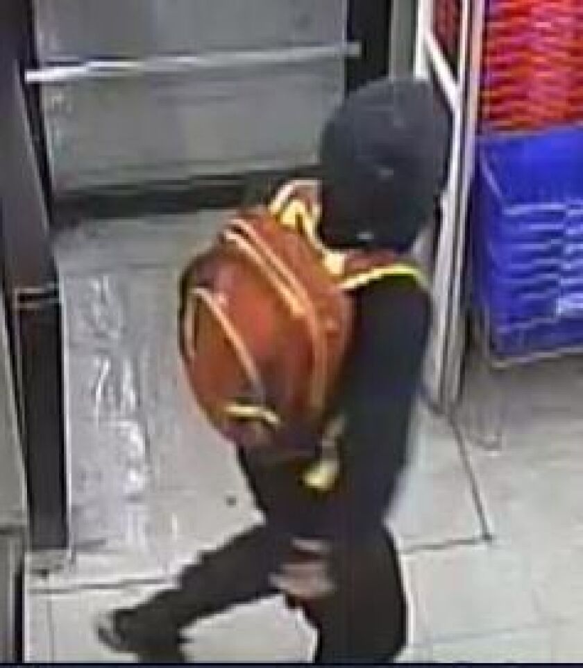 Surveillance photos of the suspects wanted for shooting a clerk during a robbery Sunday night at a store in Lansing. | Lansing police