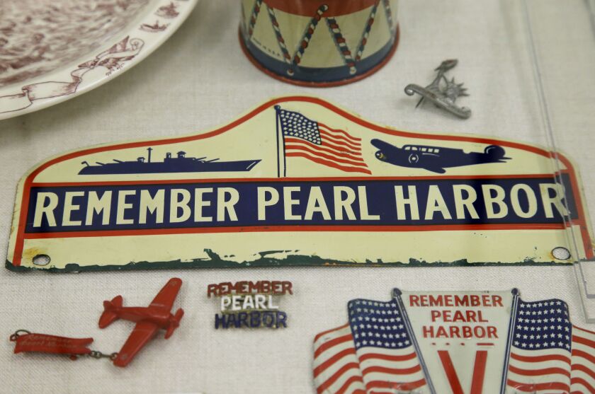 Placards and mementos with the phrase “Remember Pearl Harbor” are on display as part of an exhibit at The Museum of World War II, Boston, in Natick, Mass. (AP Photo/Steven Senne)