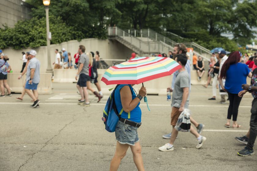 A spectator walks by with an umbrella as it starts to rain outside the main entrance during the Xfinity Series Nascar The Loop 121 Race, Saturday, July 1, 2023.