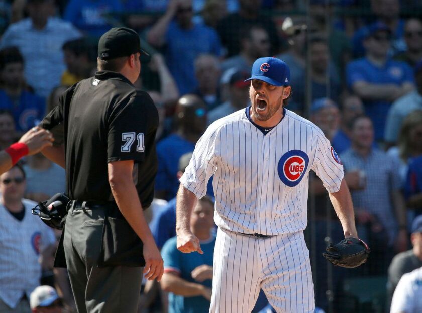 Cubs starting pitcher John Lackey lets umpire Jordan Baker have it Friday at Wrigley Field. | Charles Rex Arbogast/Associated Press