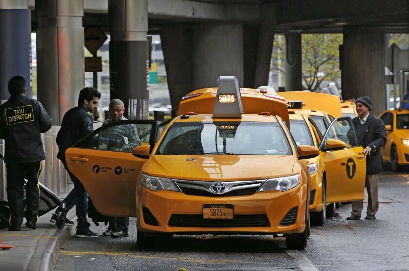 Taxi drivers queue up to pick up passengers outside the arrivals area at LaGuardia Airport, in New York. There are similar charges for limousine, Uber and Lyft drivers as well as shuttle buses for hotels, car rental companies and off-airport parking lots.