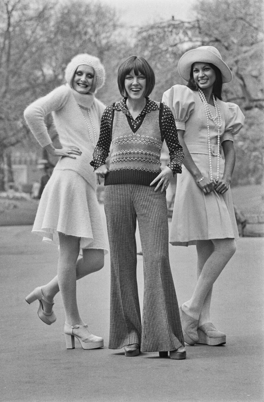 British fashion designer Mary Quant is shown in this 1972 file photo with two models at the launch of her Ginger Group autumn collection in London. Lorain (left) wears a knitted sweater and skirt in pink mohair called “Sugarplum,” and Freddie (right) wears a pink woolen flannel dress with puffed sleeves and a matching hat, called “Marshmallow.”