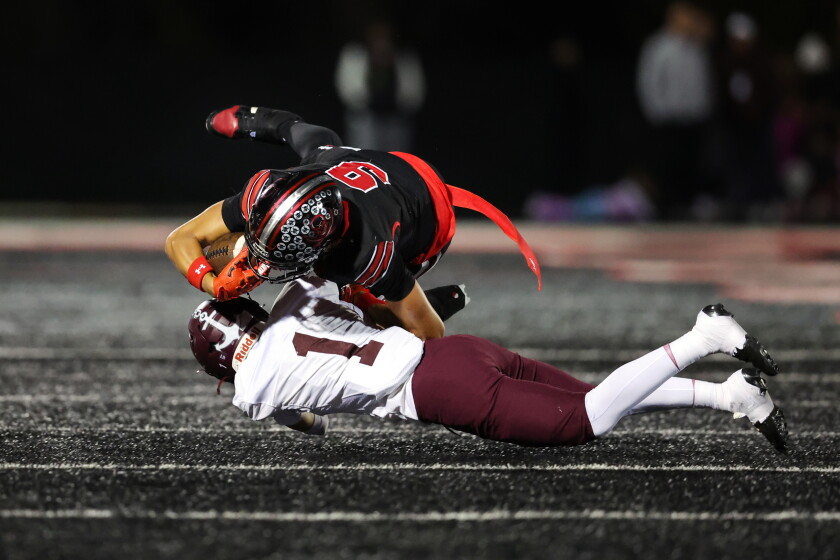 Bolingbrook's Curtis Stubbs II (9) carries the ball for a first down against Lockport's Maloney Andrew (11) during round one of the IHSA Class 8A playoffs.