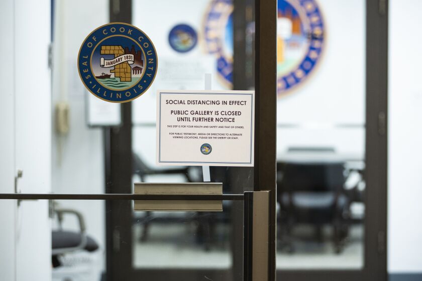 “Social distancing in effect” signs posted at the Cook County Board of Commissioners meeting room last month.