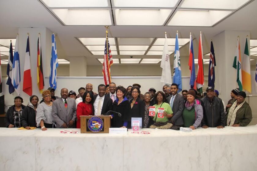 Janette and Willie Wilson (at lectern), Cook County Commissioner Richard Boykin, City Treasurer Maria Pappas and Tanya Woods, executive director of the West Side Justice Center, with some of the Cook County homeowners who had their taxes paid as a “gift”