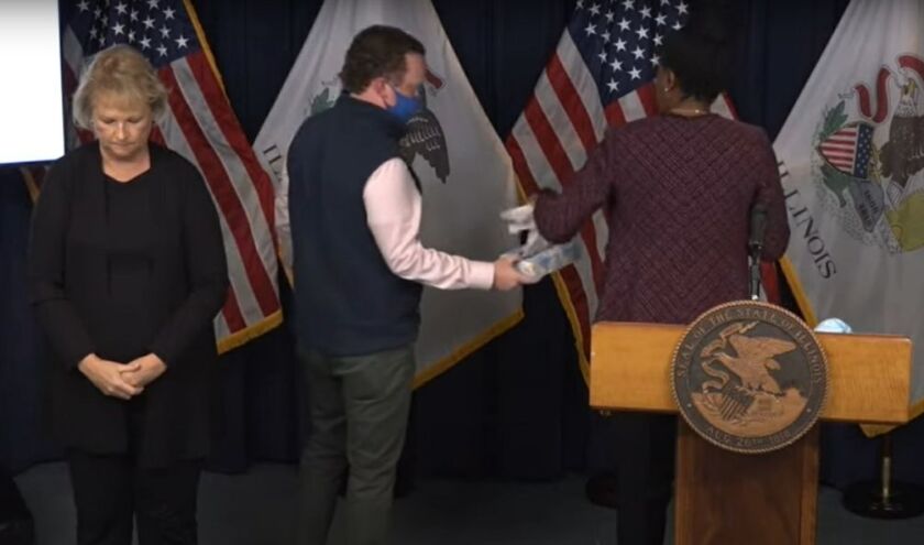Dr. Ngozi Ezike is offered tissues during Friday’s daily coronavirus briefing.