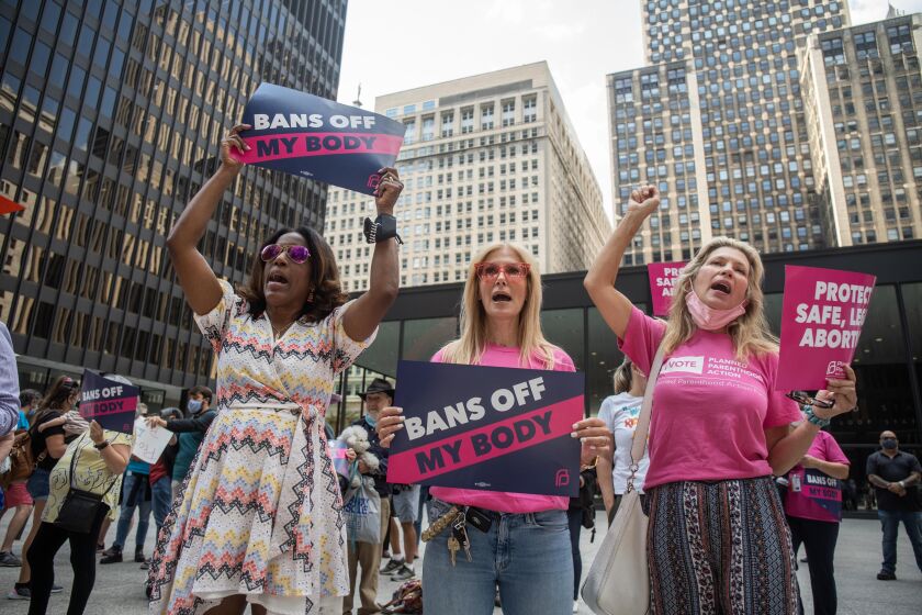 (From left) Cook County Board Commissioner Donna Miller, Stacy Michelon and Laura Tucker chant during the “Bans Off My Body” rally, decrying Texas’ new law that bans most abortions after six weeks into pregnancy, Friday afternoon at Federal Plaza in the Loop.