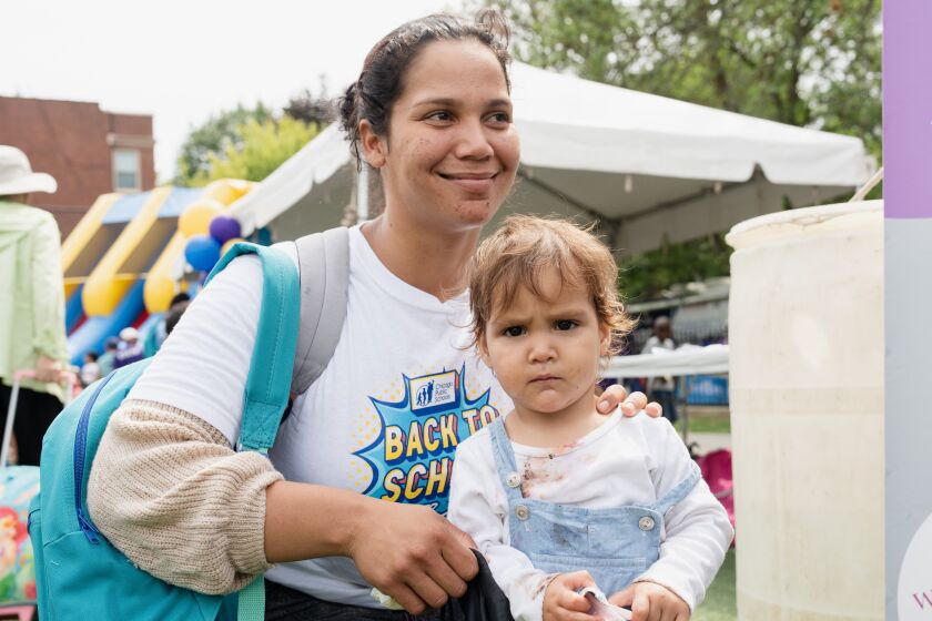 Rosalin Nuñez and her daughter, Jana Valentina Salinas Nuñez, 1, from Venezuela, join a back-to-school event hosted by Chicago Public Schools’ Family and Community Engagement (FACE) department, which had giveaways and programs for Chicago Public Schools students, including new students who are seeking asylum and their families, outside the Eugene Field Elementary School in the Rogers Park neighborhood, Friday, Aug. 11, 2023.