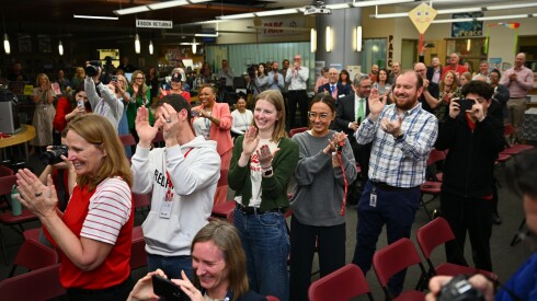 Students and colleagues applaud as social studies teacher Seth Brady is announced as the 2026 Illinois Teacher of the Year at Naperville Central High School, April 16, 2026.