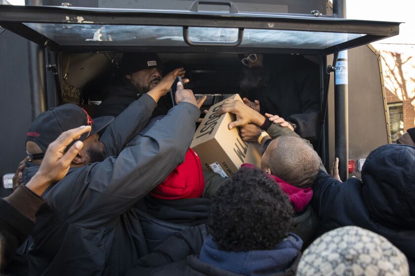 Kanye West’s team hands out free pairs of his much-anticipated Yeezy QNTM (Quantum) shoes on West Madison near South Leavitt, just west of the United Center, Friday afternoon.