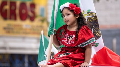 Aubree Lugo, 4, sits on a car that is carrying Mexican flags during the 20th annual Mexican Independence Day Parade along West 18th Street in the Pilsen neighborhood, Saturday afternoon, Sept. 10, 2022.