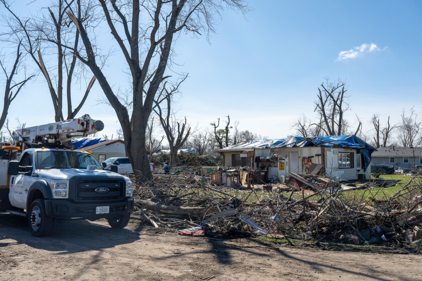 Debris litters the yards of tornado-damaged homes in a residential neighborhood on Thursday, March 12, 2026, in Aroma Park, Ill. Tornadoes moved through the area on Mondh