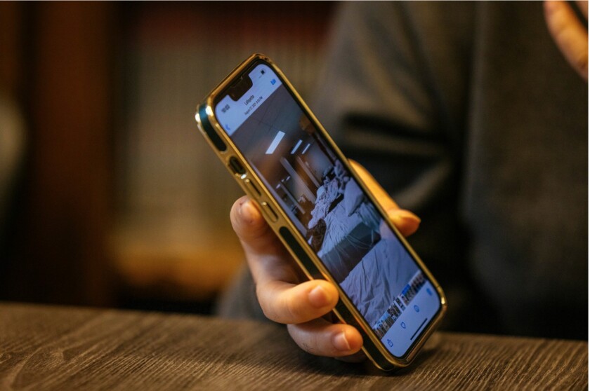 Aziz displays a photo on his phone that shows the room where he slept while staying at a refugee camp in Wisconsin.