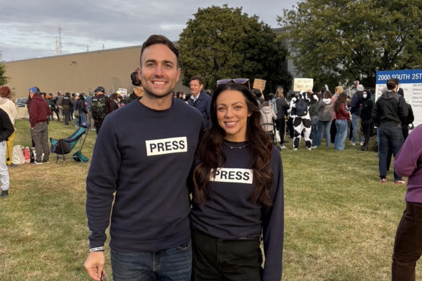 Dylan Blaha and Demi Palecek, two active members of the Illinois National Guard, attend a protest in Broadview on Friday. They are wearing sweatshirts to honor journalists killed in Gaza.