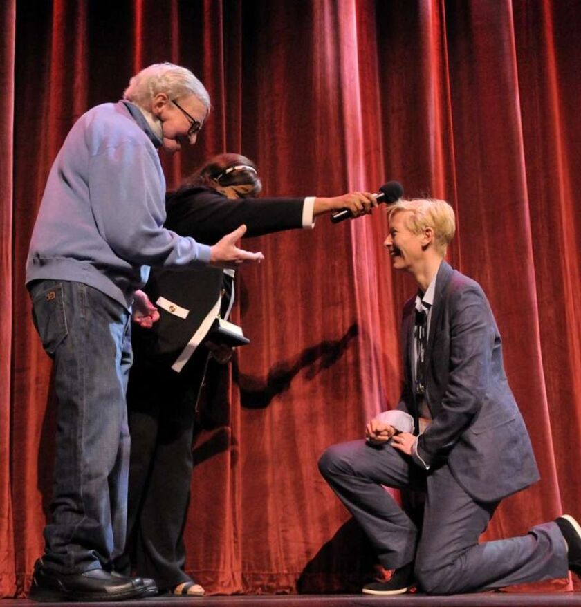 Actress Tilda Swinton (right) kneels before Roger and Chaz Ebert at Ebertfest 2011. | Thompson.McClellan