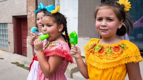 From left: Xochitl Ponce, 8, holds a snow cone while Noemi Ponce, 6, eats a popsicle and Xiomara Ponce, 7, looks at the camera during the 20th annual Mexican Independence Day Parade along West 18th Street in the Pilsen neighborhood, Saturday afternoon, Sept. 10, 2022.