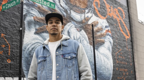 Chicago artist Asend starts in front of the Caleb Williams mural he painted.