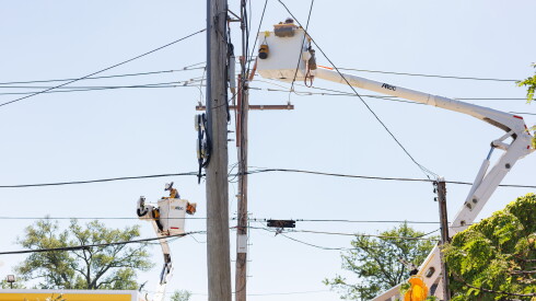 Workers repair power lines in the 7100 block of South Green Street in Englewood after a storm in June.
