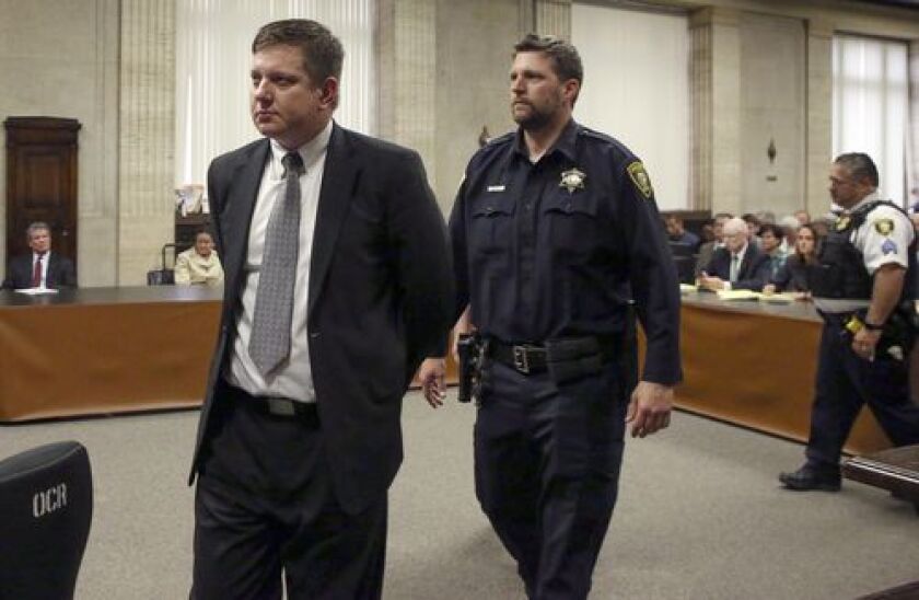 Chicago police Officer Jason Van Dyke, left, is taken into custody Friday after jurors found him guilty of second-degree murder and aggravated battery in the 2014 shooting of black teenager Laquan McDonald at the Leighton Criminal Court Building. | Antoni