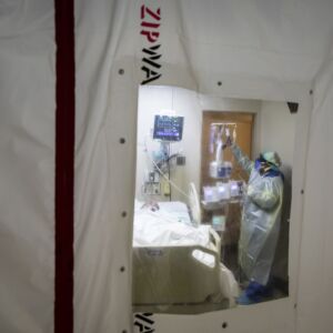 Nurse Tamara Jones checks on a patient with COVID-19 and on a ventilator in the Intensive Care Unit at Roseland Community Hospital on the Far South Side, Tuesday afternoon, Dec. 8, 2020. Zip walls and negative pressure machines were installed in the hospital’s ICU in early December.