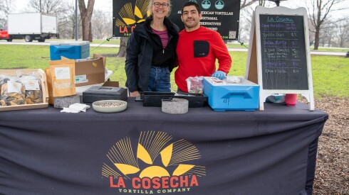Owner of La Cosecha Tortilla Company, Jonathan Correa (right) stands with a worker at their booth at the Green City Market in Lincoln Park on Saturday, April 4, 2026. Correa said he had to raise his prices to help cover rising gas costs.