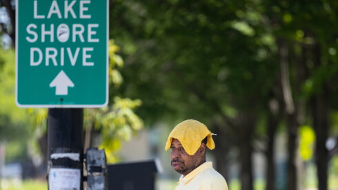 A man covers his head with a wet rag to stay cool in Bronzeville amid a heat wave Wednesday.