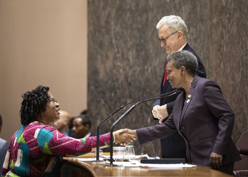 Chicago City Treasurer Melissa Conyears-Ervin shakes hands with Mayor Lori Lightfoot following adjournment of their first Chicago City Council meeting.