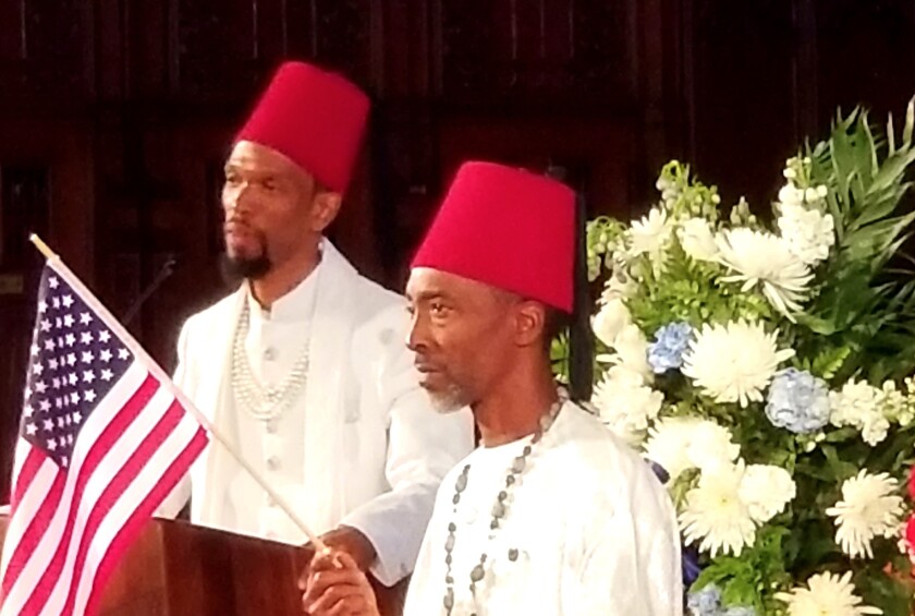 Rodney White-EL (left, at the podium) speaking during the funeral Friday for his son Khalil White-EL.
