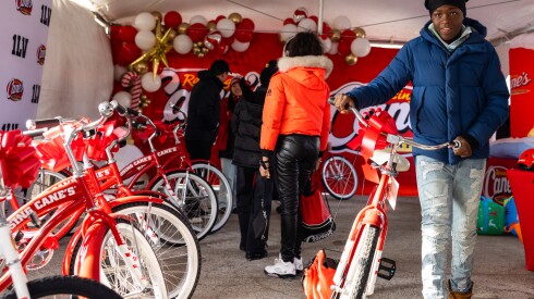 A child walks alongside his new bike donated by Chance the Rapper’s nonprofit, SocialWorks, in partnership with Raising Cane’s on the Far South Side, Monday, Dec. 15, 2025.
