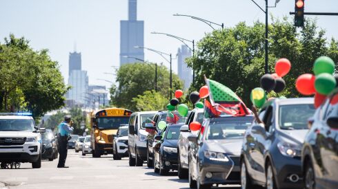 A police officer watches the West Garfield Park Juneteenth Parade along West Monroe Street in the West Garfield Park neighborhood, Saturday morning, June 18, 2022.