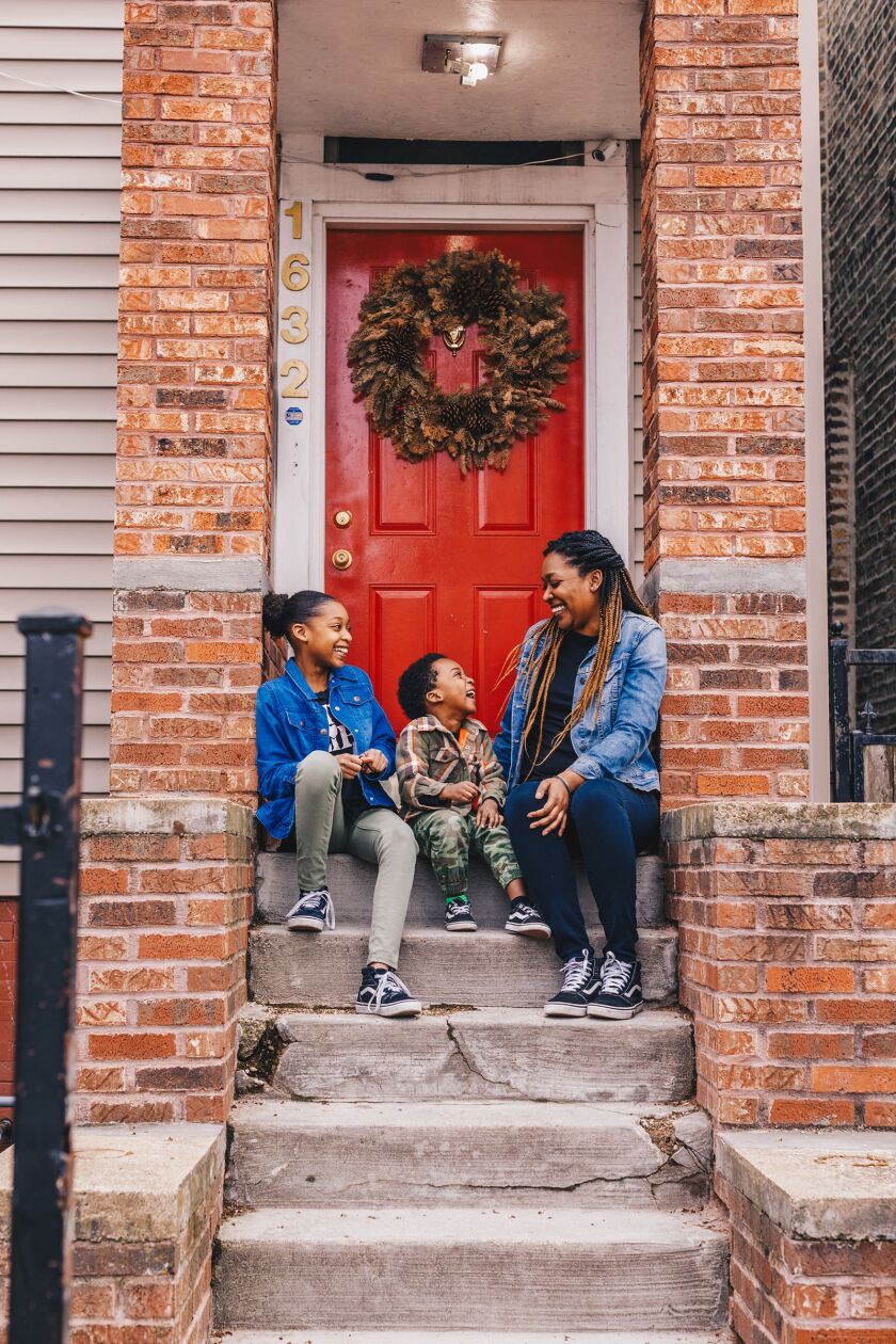 Sameka Gates and her kids, Kylee, 11, and Ethan, 5, sit on their front steps in Hermosa.