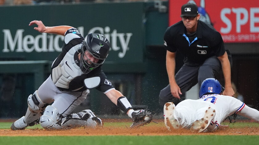 Ezequiel Duran, bottom right, slides into home plate against White Sox catcher Kyle Teel in the second inning Monday at Texas.