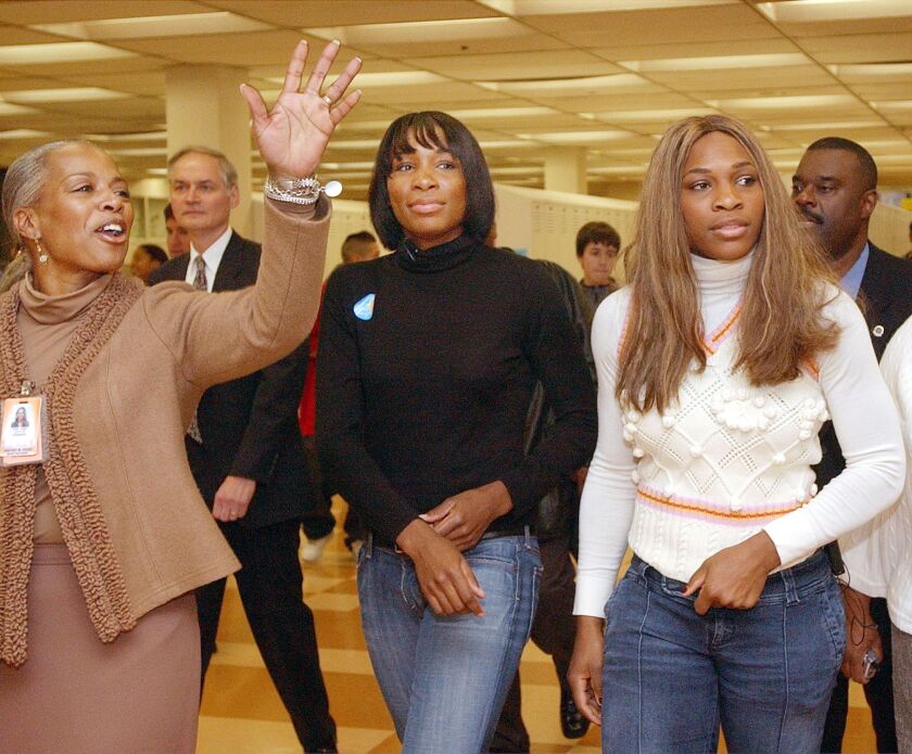 Joyce Kenner, principal of Whitney Young high school, shows Venus Williams (center) and Serena Williams (right) around the Near West Side school in November 2004.