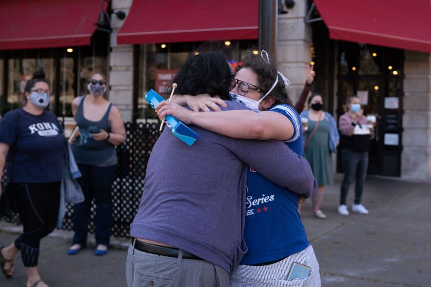 Mugsie Palmer Pike hugs her friend Sam Sandmal on North Sheridan Road in the Rogers Park neighborhood, where dozens gathered after President-elect Joe Biden’s victory was announced on Saturday.