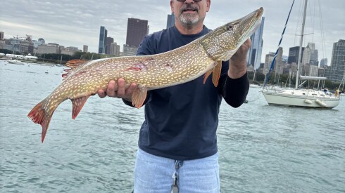 Marc DiMenna holds a big northern pike he caught while fishing smallmouth bass on the lakefront.
