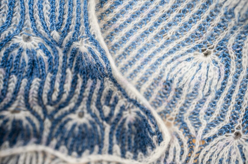 A blue and white knitted pattern called the Joyous Shawl pattern.