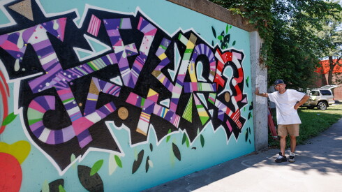 Garrett Munski stands next to his portion of the graffiti wall on Green Bay Road in Evanston.