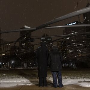 Mayor Lori Lightfoot (left) and First Lady Amy Eshleman hold candles while looking toward a darkened Chicago skyline from Millennium Park during a National COVID-19 memorial, Tuesday, Jan. 19, 2021.