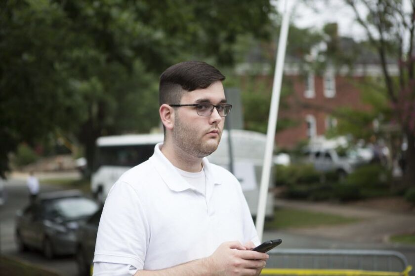 James Alex Fields Jr. stands on the sidewalk looking at the procession of the clergy as they gathered at McGaffey park on Aug. 12, 2017, ahead of a rally in Charlottesville, Virginia. He is accused of ramming his car into a crowd of counter-protesters, ki
