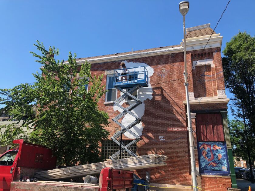 The artist ZorZorZor painting the mural at 18th Place and Throop Street earlier this year.