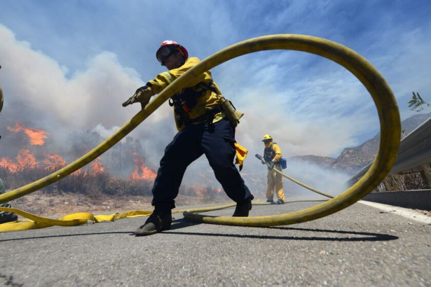 Firefighters battle the Bluecut Fire along Swarthout Canyon Road in the Cajon Pass, north of San Bernardino, California, on Tuesday, Aug. 16, 2016. | Will Lester/The Sun via AP