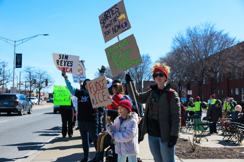 Los manifestantes sostienen carteles y gritan el sábado durante una manifestación de No Kings frente al Ayuntamiento de Cicero.
