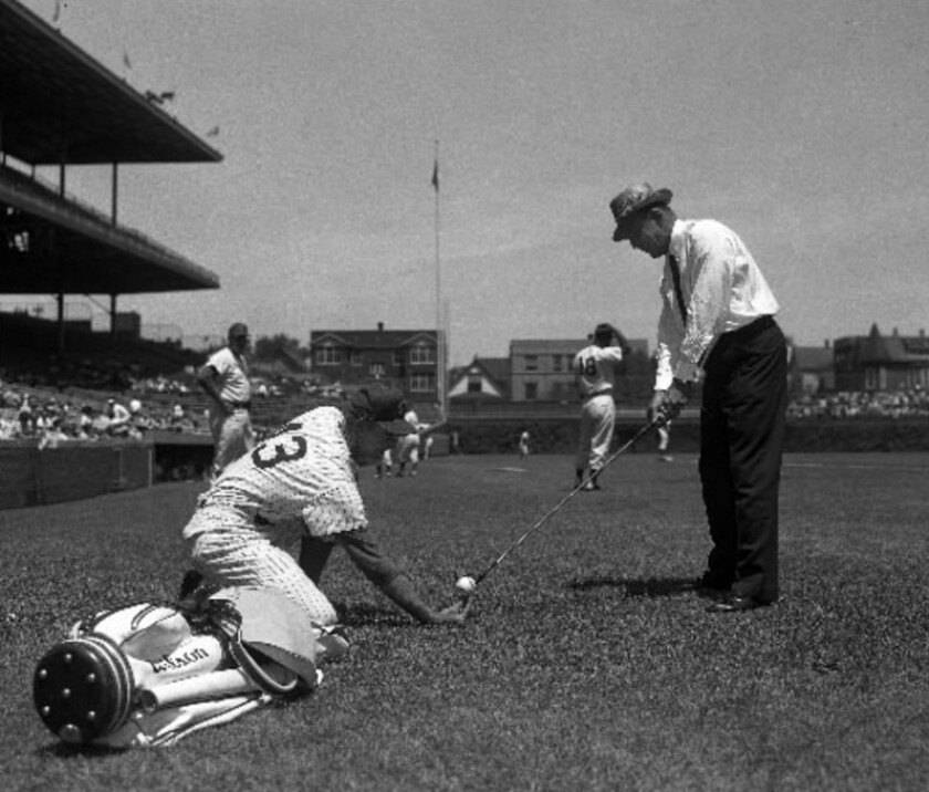 Golfer Sam Snead takes aim in Wrigley Field with the help of Cubs pitcher Don Cardwell on July 6, 1961. Ten years earlier, Snead struck the Cubs scoreboard with a lazy 4-iron from home plate and then cleared the scoreboard with a 2-iron. | Sun-Times Media