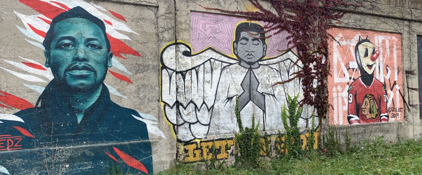 The mural at left, by the 29-year-old Berwyn artist who goes by Fedz, features Chicago rapper Lupe Fiasco. At far right, the 34-year-old Pilsen artist who goes by Raya created a mural featuring a signature character of his wearing a Blackhawks jersey because he’s a fan of the team. The character is meant to be “a little devil, but not evil, just a trickster,” Raya says.