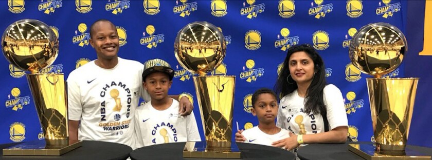 David Kelly and his family pose with the Warriors’ recent NBA Championship trophies.