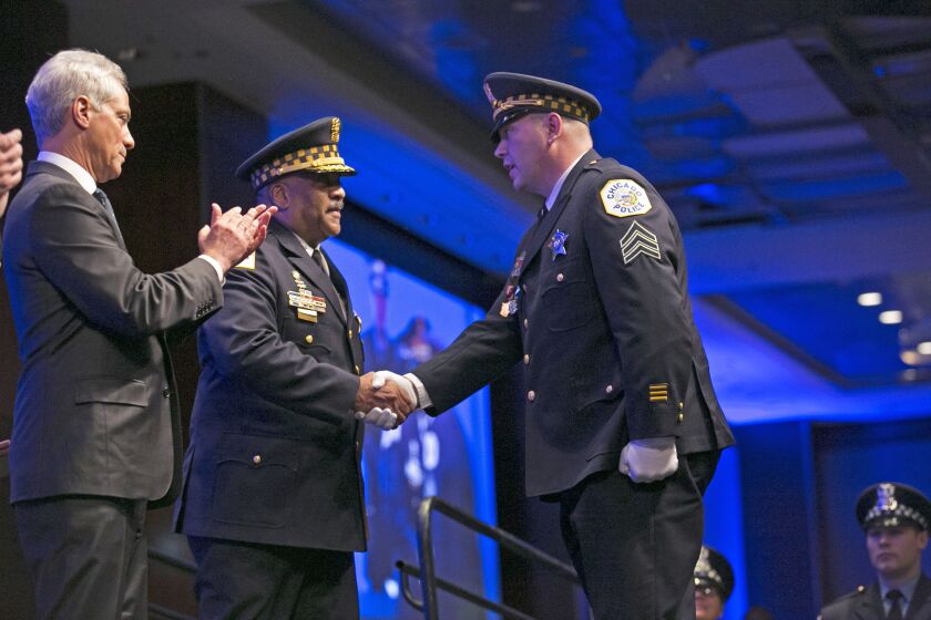 Chicago Police Sgt. Leo Augle (right) was with fellow officer Colin Ryan in a surveillance van when they were wounded in an ambush shooting last year. On Friday, Augle and Ryan received the department’s highest honor, the Police Medal. Presenting it were