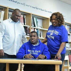 Phillips’ DeAndre Johnson signs a letter of intent with Indiana State. His parents Artize Johnson and mom Shanell look on. Worsom Robinson/For the Sun-Times.