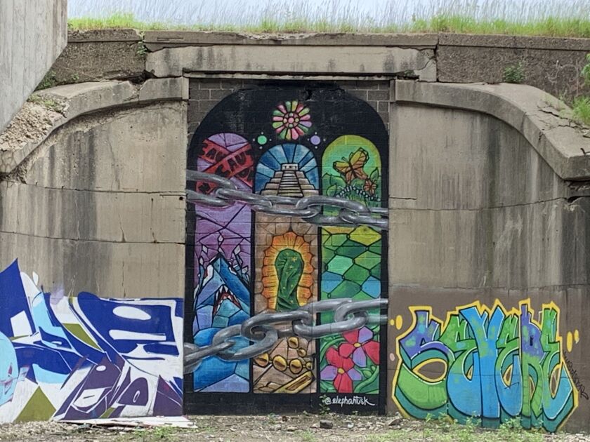 This mural, resembling stained glass like you might see in church, is by artist Jose Lopez. The South Chicago artist, who goes by “Tusk,” says, “Being Mexican, you grow up with these Catholic motifs, so it was a reference to that. And I incorporated things we see growing up in Chicago. The concept overarching here is referencing identity,” with the chains representing “obstacles that can get in the way.”